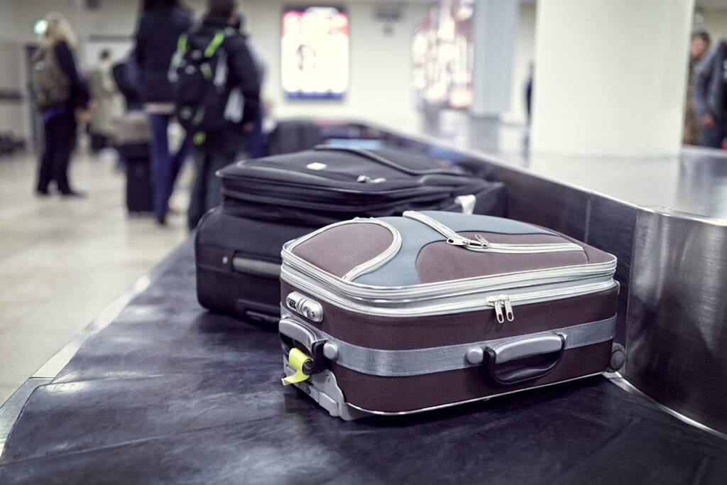 Suitcase on luggage conveyor belt in the baggage claim at airport