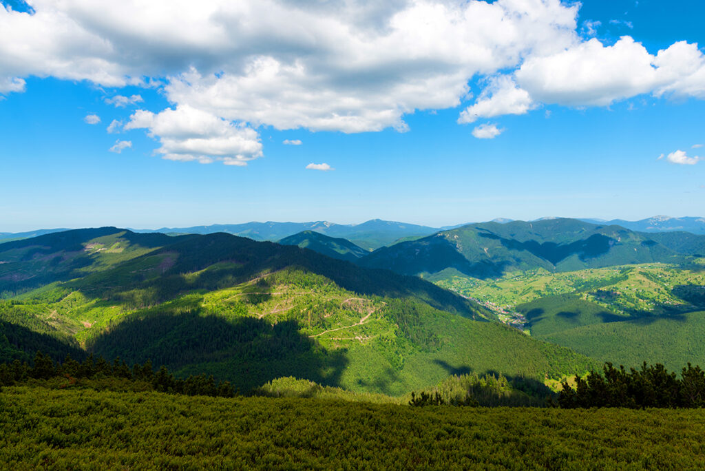 Mountains in summer sunny day with blue sky and white clouds